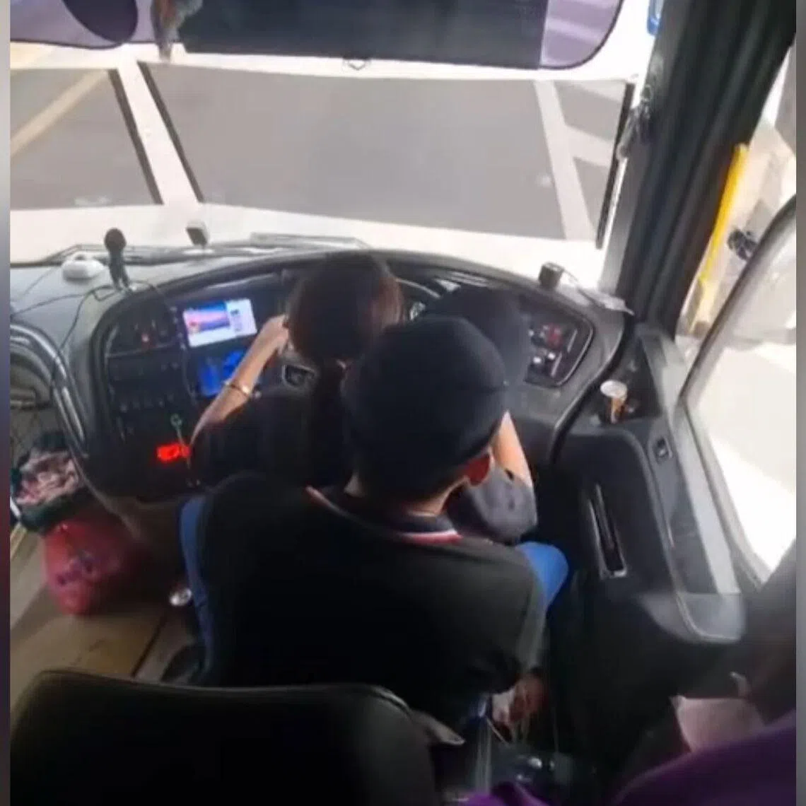 The viral footage shows a woman sitting on the driver’s lap and holding the steering wheel while the bus is in motion. 