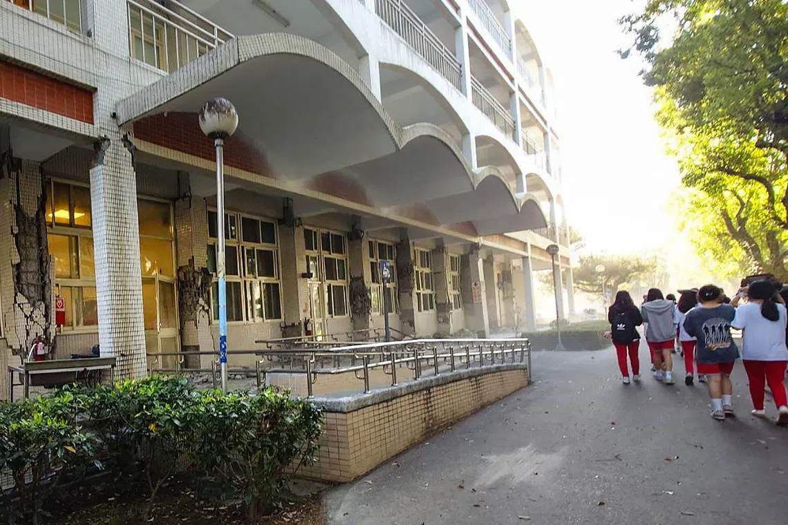 Students walking past a damaged building in the National Hualien Girls' High School in Hualien, following a major earthquake in eastern Taiwan on April 3, 2024.
