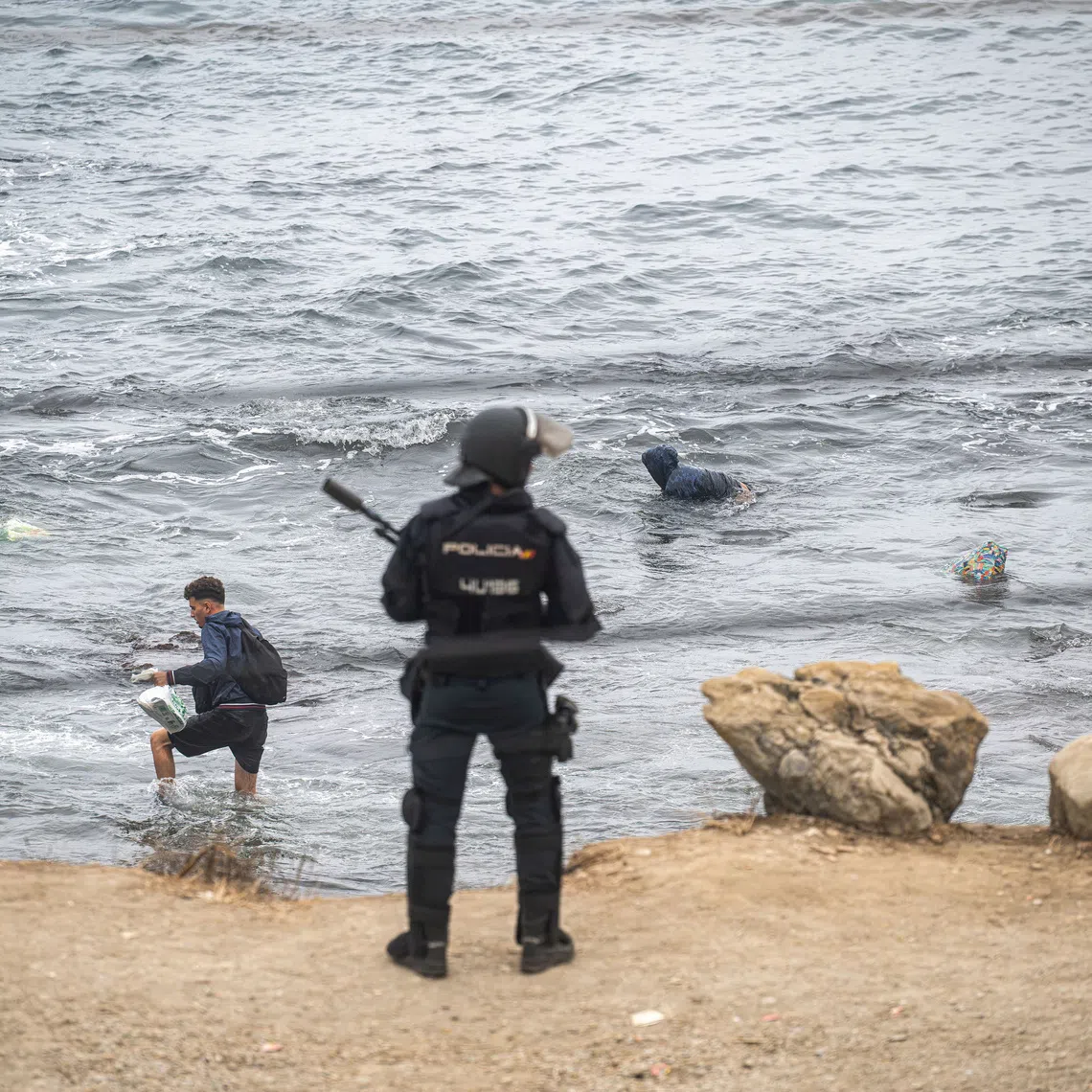 FILE PHOTO: Migrants swim at El Trampolin beach heading to the nearby El Guano, an immigrants' settlement, as Police clear up an encampment of migrants at El Trampolin beach in the Spanish enclave of Ceuta, in Ceuta, Spain, October 4, 2026. REUTERS/Marcos Moreno