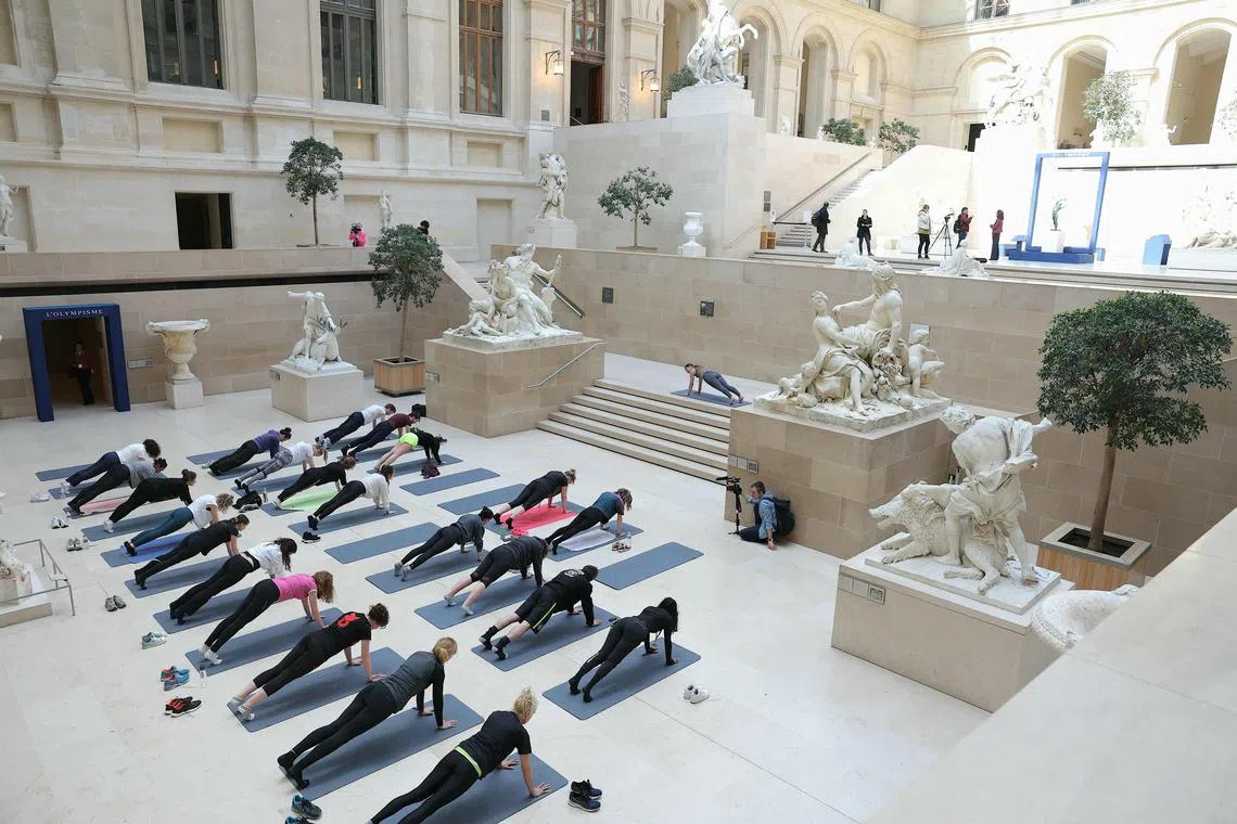 Dancers take part in a rehearsal of "Les visites sportives" by artist and choreographer Mehdi Kerkouche in the Cour Marly at the Louvre Museum in Paris on April 23, 2024. 