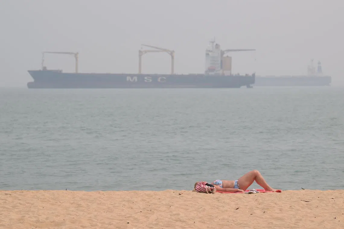 A woman sunbathing under the hazy sky at East Coast Park at 3pm on Oct 7. The 24-hour PSI as of 3pm in the east was 117.