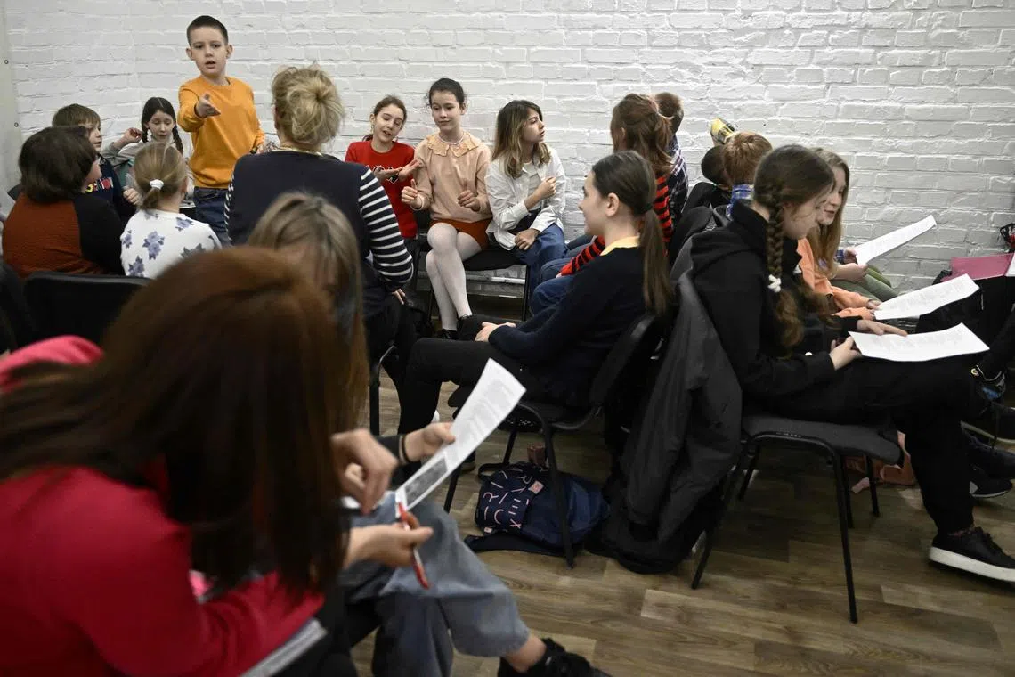 Children study in an air-raid shelter in the cellar of a school after an alarm signal in Kyiv on March 23.