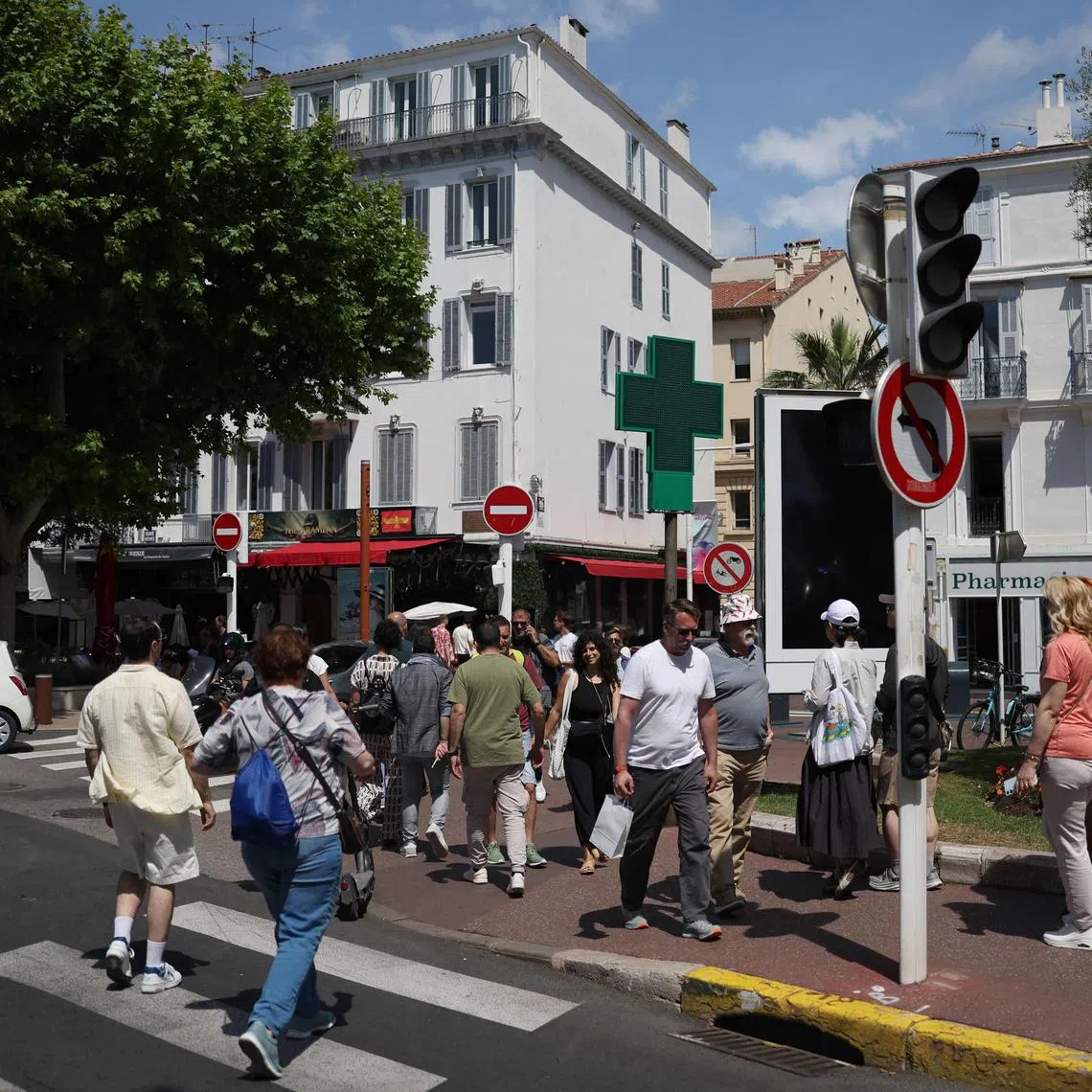Pedestrians crossing a street in Cannes during a traffic light outage caused by the power cut on May 24.