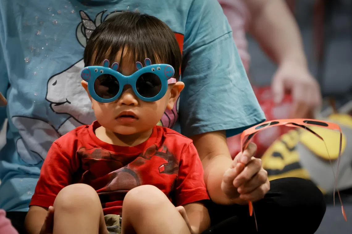 Two-year-old Ezra Tee watching a live stream of the solar eclipse from Exmouth in Western Australia, at the Singapore Science Centre, April 20, 2023.