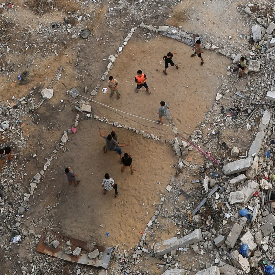 Palestinian children play volleyball amid rubble of buildings damaged in the war, in Gaza City, on Sept 15.