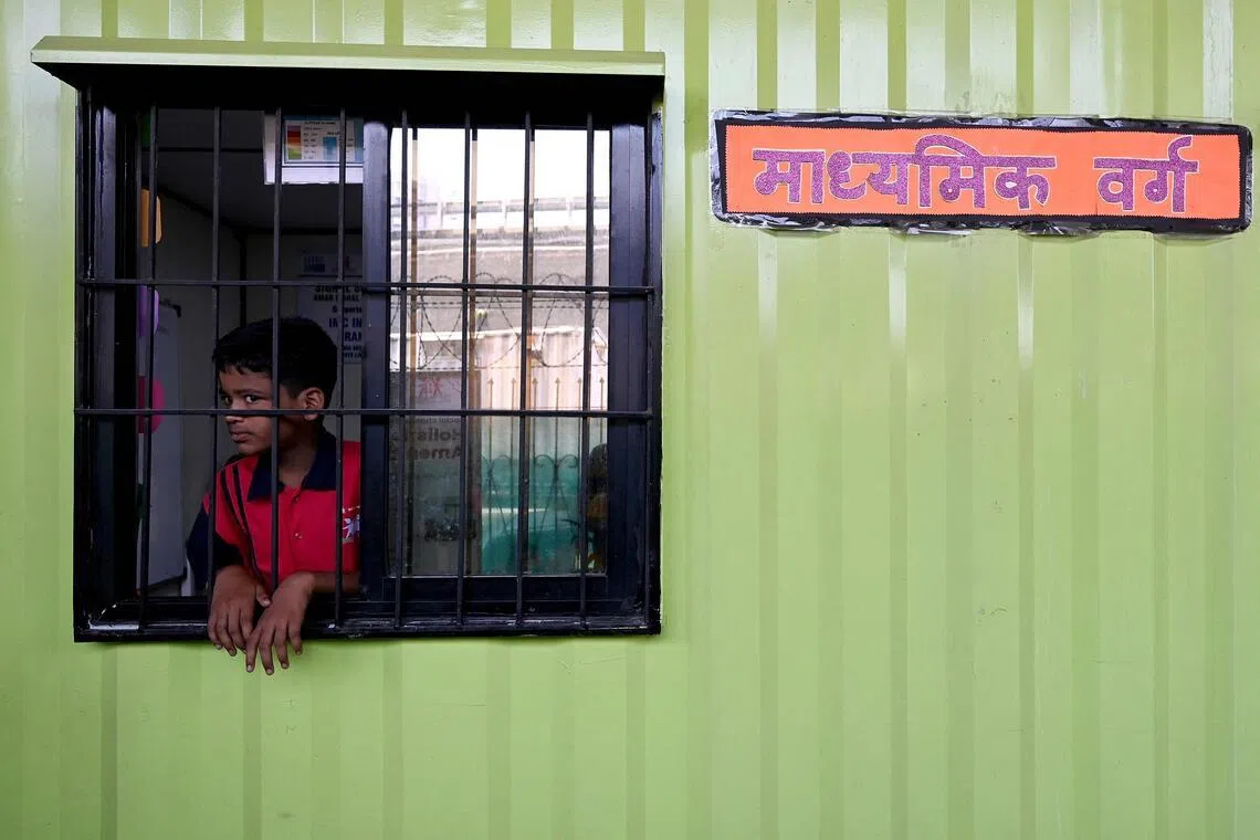 A boy looks out from a window of his classroom at the “Signal Shala”, or traffic signal school, under a bridge in Mumbai, on May 18.