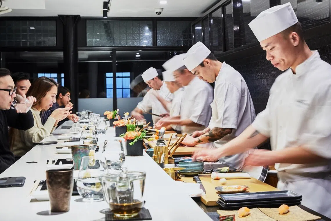 Food is prepared across a white marble counter from diners at Sushi Nakazawa in New York on Dec. 29, 2019. (Ellen Silverman/The New York Times)