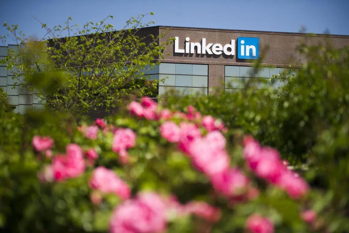 Flowers stand in front of LinkedIn Corp. signage displayed on the facade of the company's headquarters in Mountain View, California, U.S. on Thursday, April 25, 2013. LinkedIn Corp. added publishing platform Pulse, a news-reading application used by more than 20 million people in 190 countries, for news and content this month. Photographer: David Paul Morris/Bloomberg