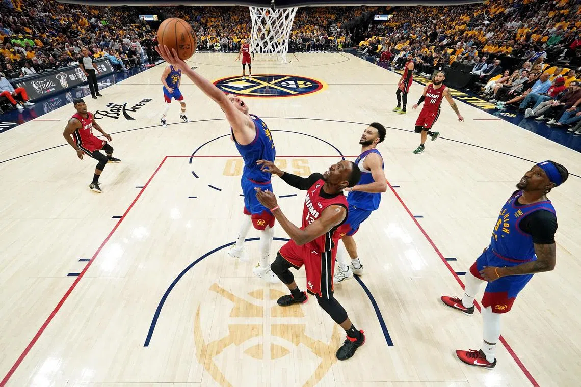 Denver Nuggets centre Nikola Jokic reaches for the ball against Miami Heat center Bam Adebayo during Game 1 of the NBA Finals.