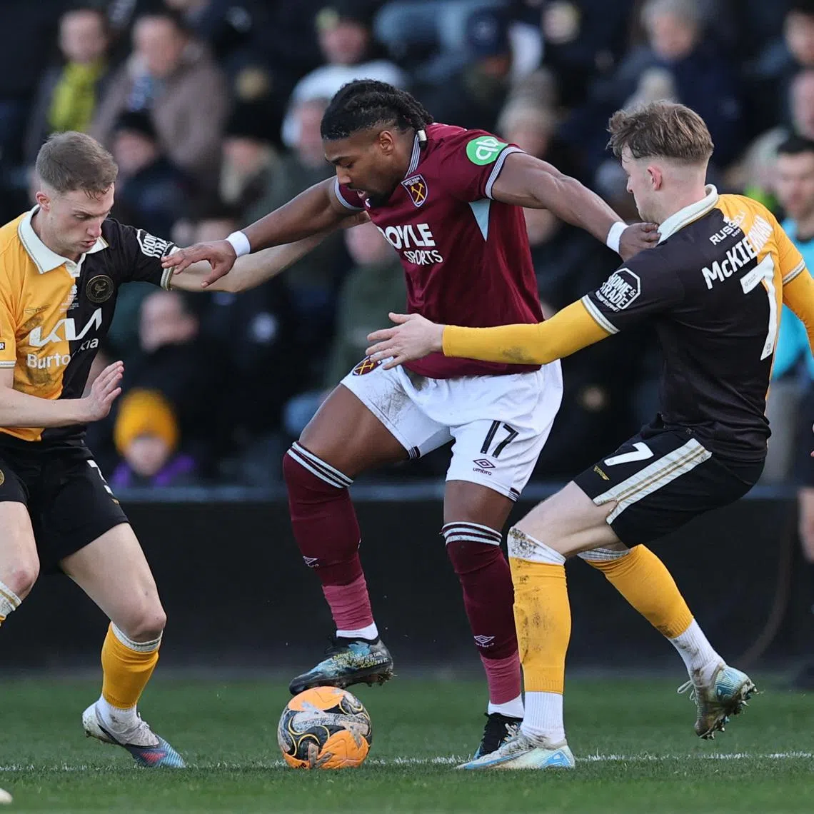 Soccer Football -  FA Cup - Fourth Round - Burton Albion v West Ham United - Pirelli Stadium, Burton-on-Trent, Britain - February 14, 2026 West Ham United's Adama Traore in action with Burton Albion's Jack Armer and Jj Mckiernan Action Images via Reuters/Andrew Boyers