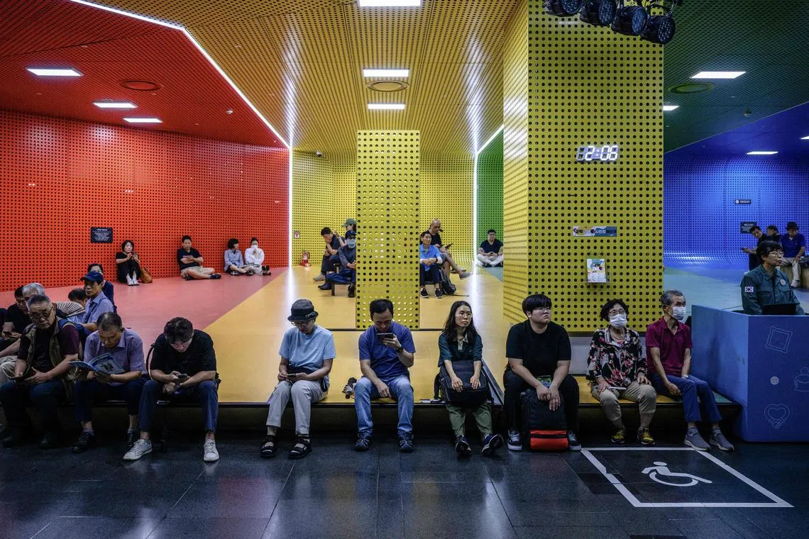 People sit at the City Hall metro station shelter during an air raid drill in Seoul on August 22, 2024.