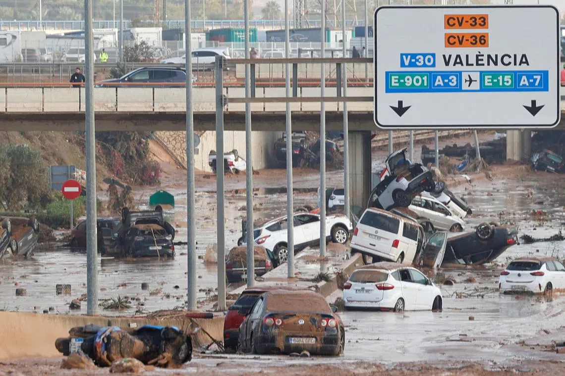 Damaged cars are seen along a road affected by torrential rains that caused flooding, on the outskirts of Valencia, Spain, October 31, 2024. REUTERS/Eva Manez
