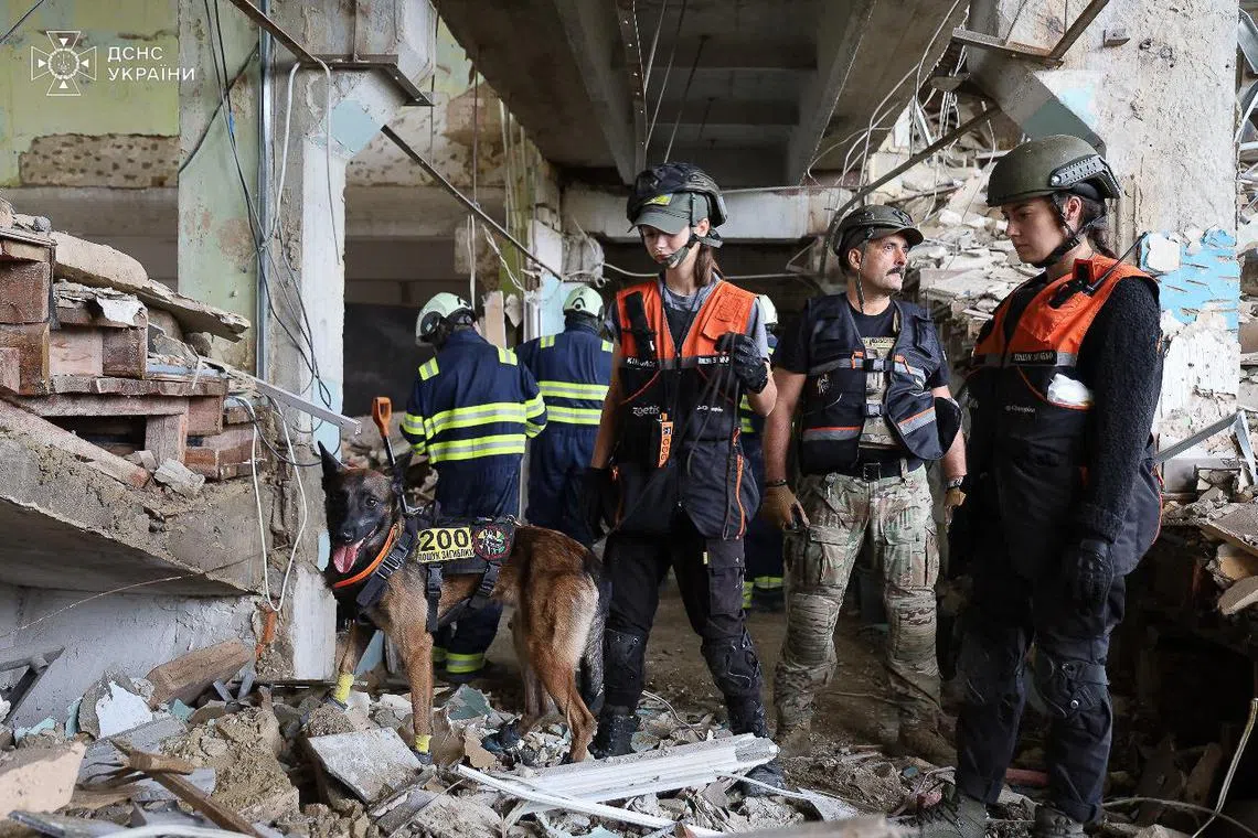 Ukrainian rescuers working at the military communications institute in Poltava, eastern Ukraine, two days after it was hit by Russian missiles.