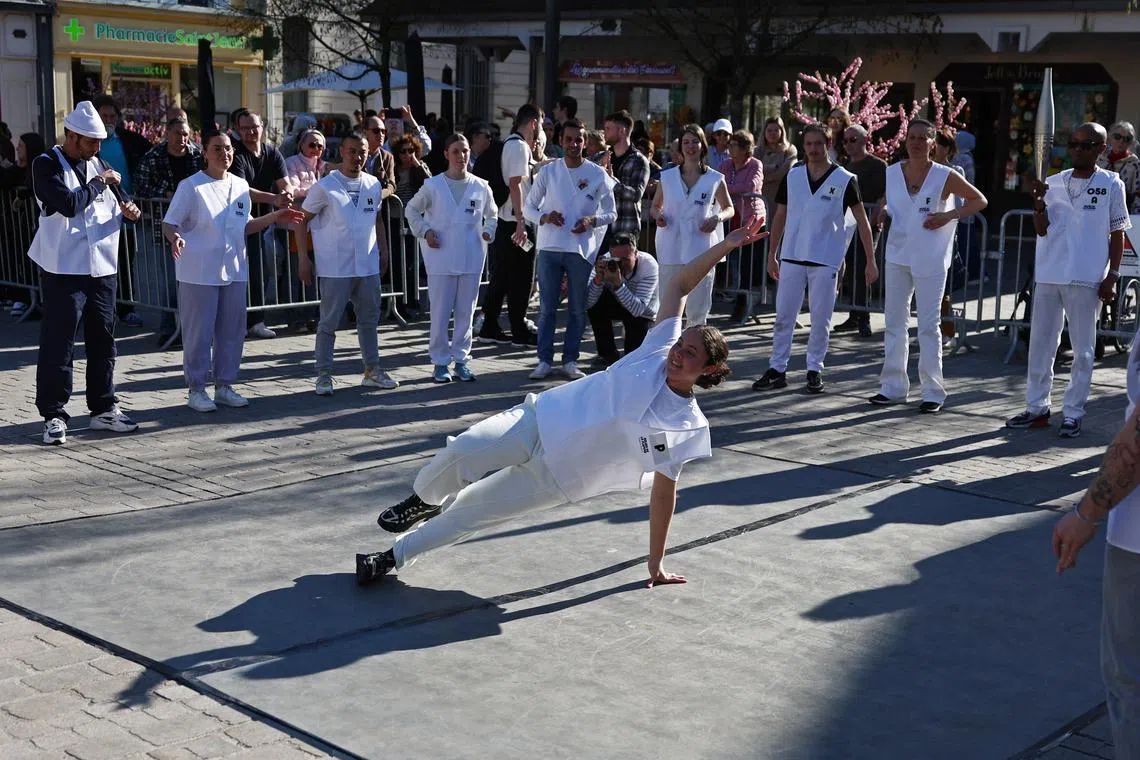 Paris 2024 Olympics - Test for the Olympics Torch Relay - Troyes, Aube, France - March 22, 2024 An acting torch bearer performs breaking during the Olympics torch relay test REUTERS/Stephanie Lecocq