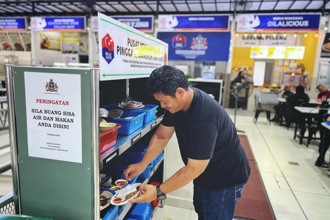A patron seen clearing his plate at a dedicated utensil return station at the Medan Niaga Kampung Melayu Majidee on May 14.
