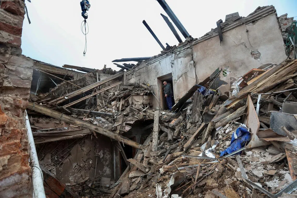 FILE PHOTO: A local resident and a rescuer stand on debris of a building of local museum heavily damaged by a Russian missile strike, amid Russia's attack on Ukraine, in the town of Kupiansk, Kharkiv region, Ukraine April 25, 2023.  REUTERS/Viktoriia Yakymenko/File Photo