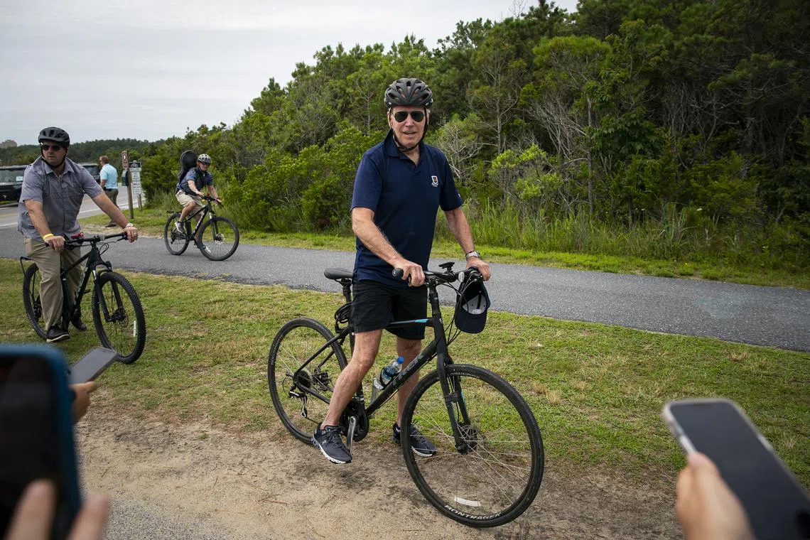 FILE — President Joe Biden speaks to reporters while biking at Gordons Pond in Rehoboth Beach, Del., on Sunday, July 10, 2022. The president’s milestone birthday has brought new attention to the gerontocracy that has led both parties for years and raised questions about when a new generation will come forth. (Al Drago/The New York Times)