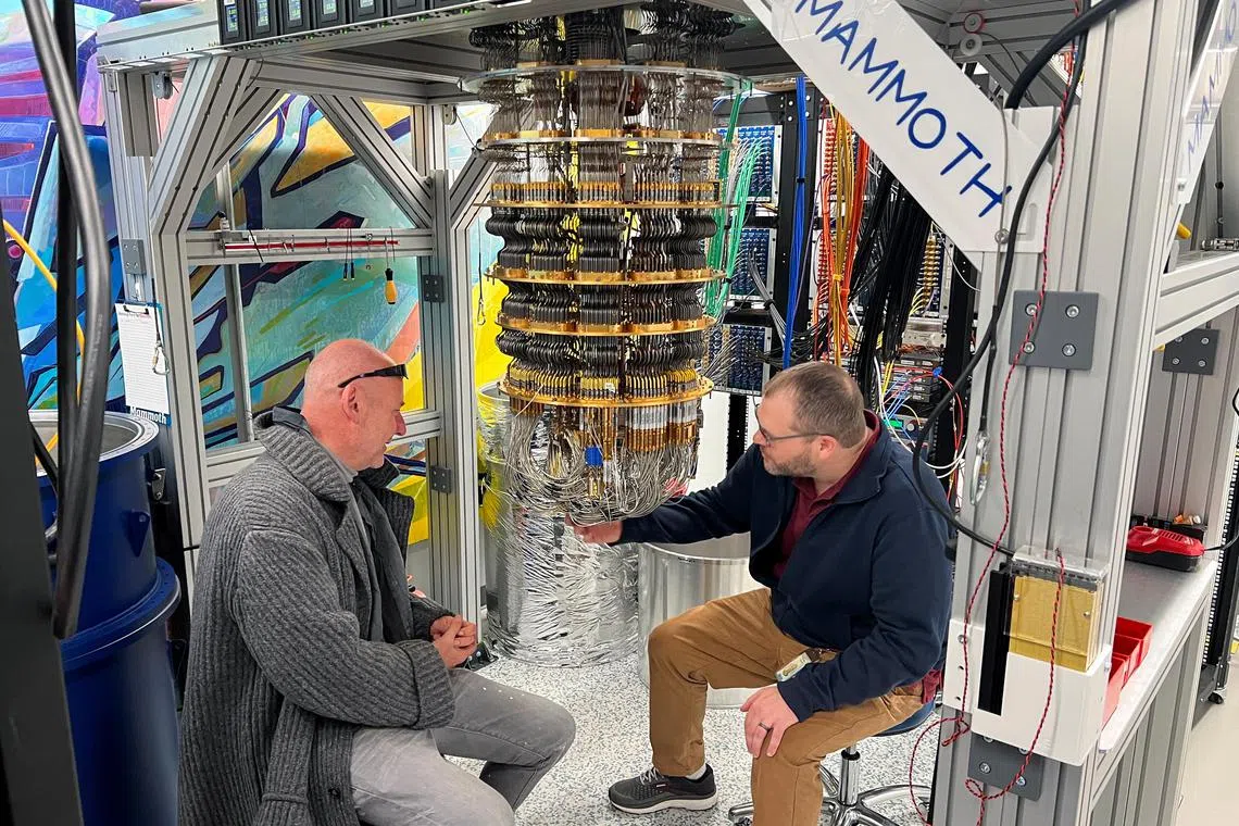 Google Quantum AI's Hartmut Neven (L) and Anthony Megrant (R) examine a cryostat refrigerator for cooling quantum computing chips at Google's Quantum AI lab in Santa Barbara, California, U.S. November 25, 2024. REUTERS/Stephen Nellis