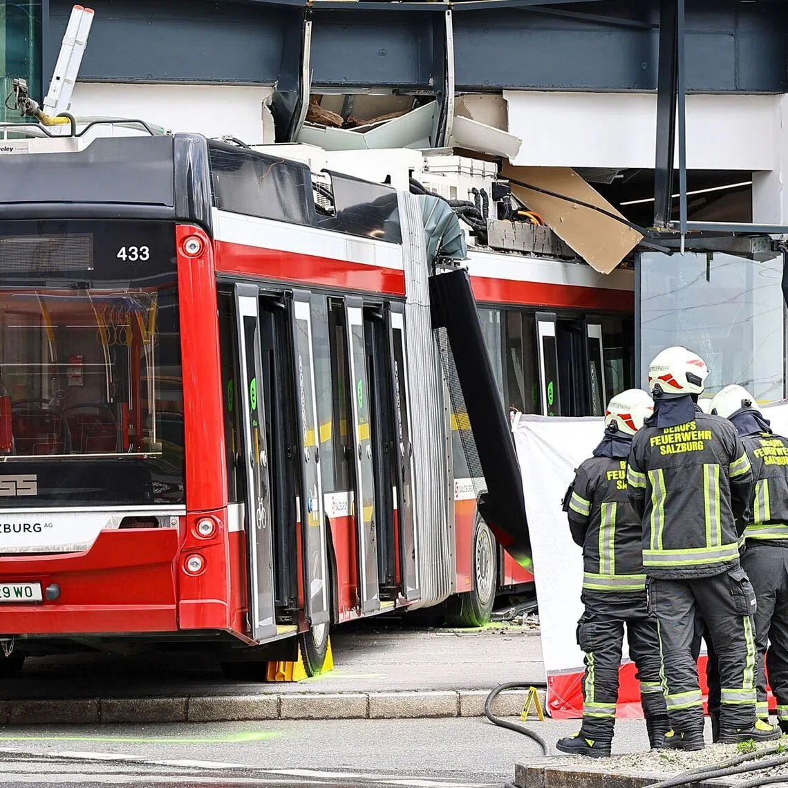 Firefighters and rescue personnel work next to a trolleybus that crashed into a supermarket in Salzburg, Austria, on April 20.