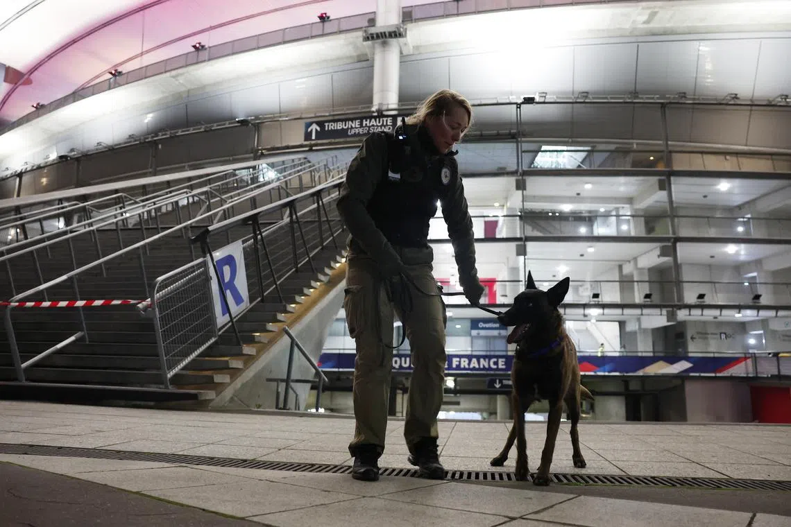 Soccer Football - Nations League - Group Stage - France v Israel - Stade de France, Saint-Denis, France  - November 14, 2024 Police officer and police dog stand outside the stadium before the match REUTERS/Gonzalo Fuentes