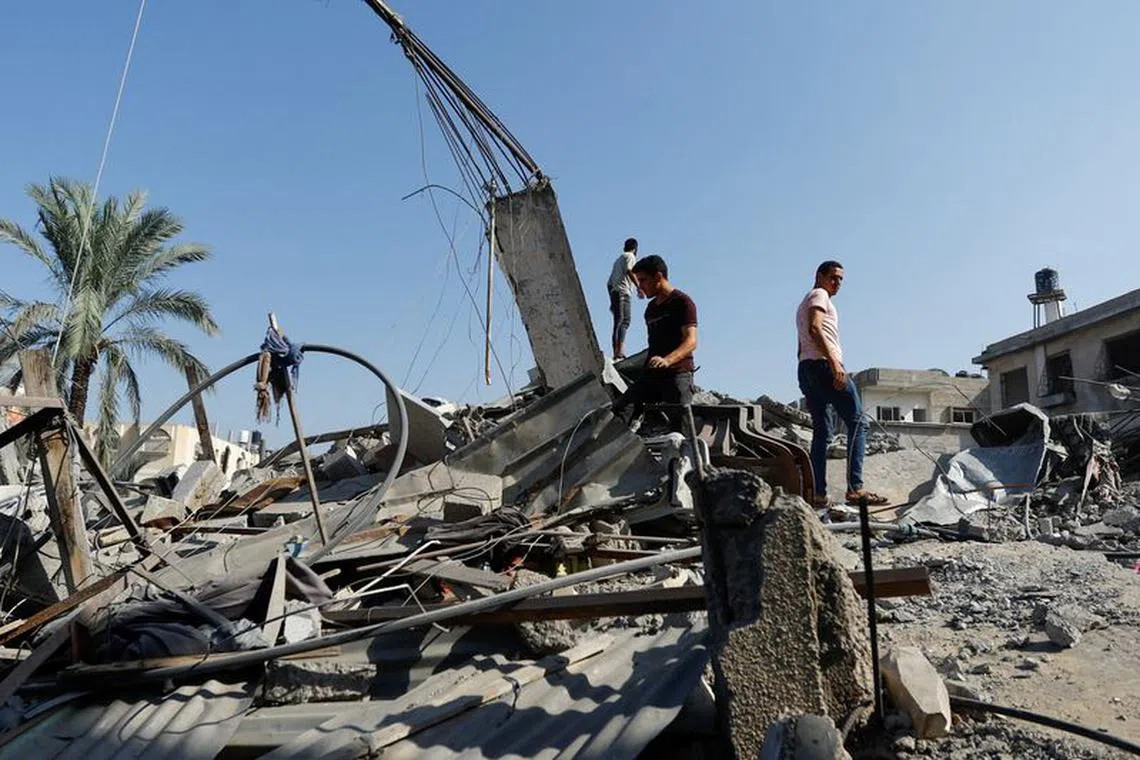 Palestinians search for casualties following an Israeli strike on a house, in Khan Younis, in the southern Gaza Strip, October 25, 2023. REUTERS/Ibraheem Abu Mustafa