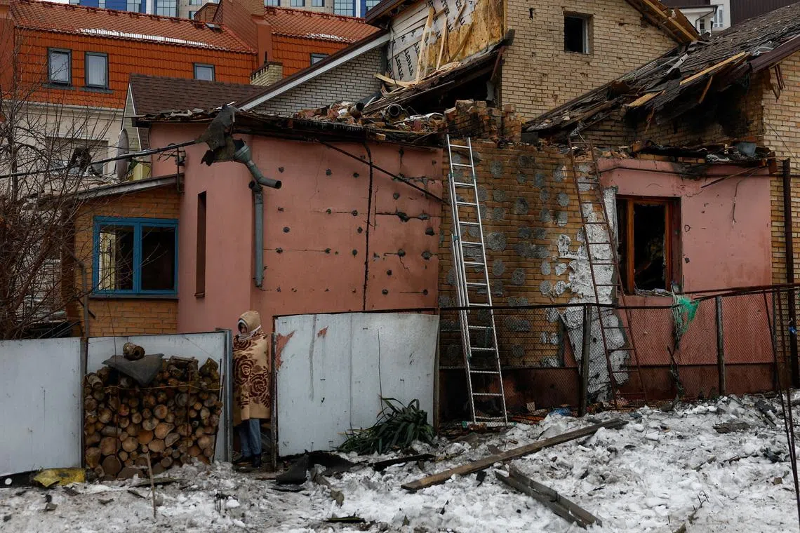 A resident walks next to her grandparents' house damaged during Russian drone and missile strikes, amid Russia's attack on Ukraine, in Kyiv, Ukraine February 26, 2026. REUTERS/Valentyn Ogirenko