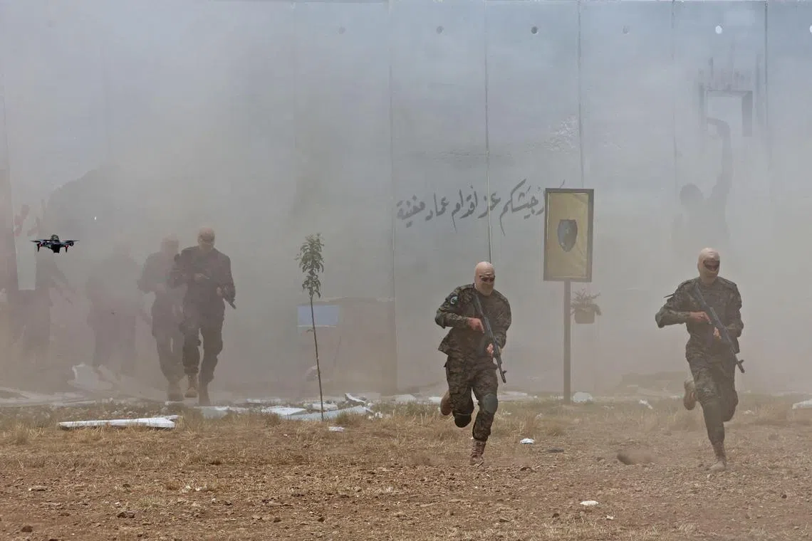 Lebanese Hezbollah fighters take part in a military exercise in Aaramta, bordering Israel, in May 2023.