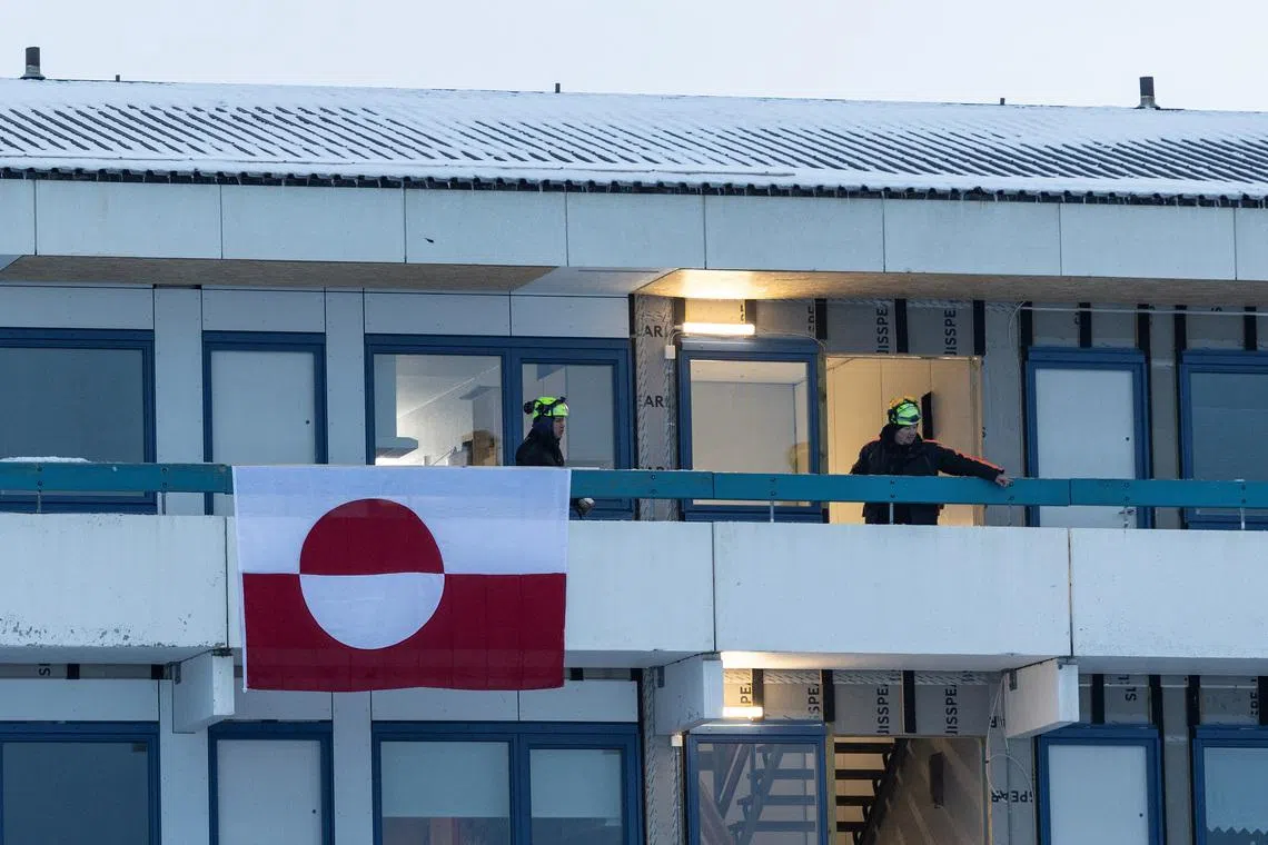 Construction workers stand on a terrace of a residential building in Nuuk, Greenland, January 14, 2026. REUTERS/Marko Djurica