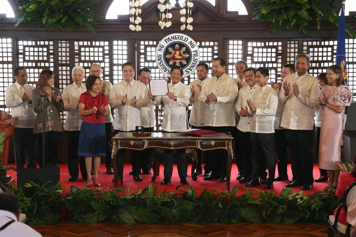 Philippine President Ferdinand Marcos Jr (centre) after signing into law the Bill creating the Maharlika sovereign wealth fund.