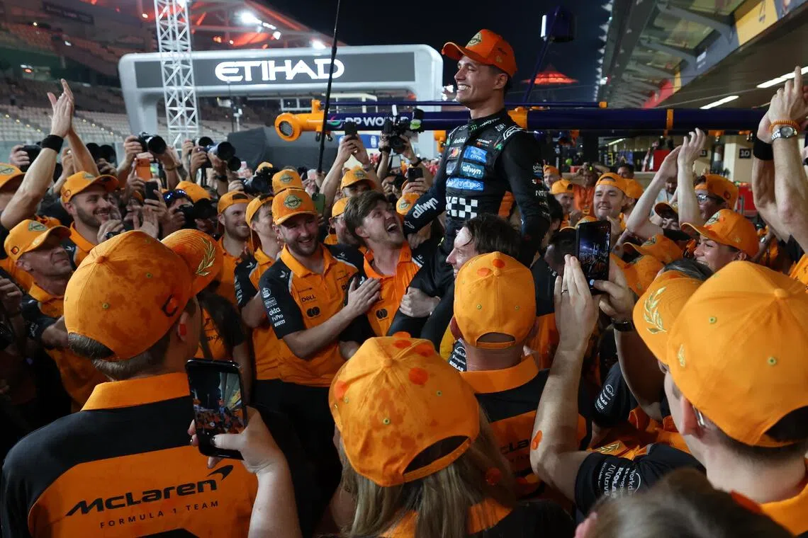 McLaren driver Lando Norris of Britain being lifted by team members after winning the 2025 Formula One drivers' world championship after the Abu Dhabi Grand Prix at the Yas Marina Circuit racetrack in the United Arab Emirates on Dec  7, 2025.