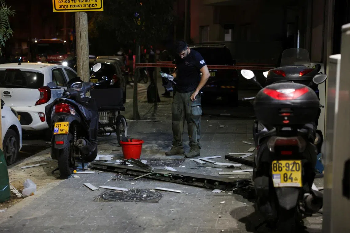 An emergency worker inspects debris at the site of an explosion, amid the Israel-Hamas conflict in Tel Aviv, Israel July 19, 2024. REUTERS/Ricardo Moraes