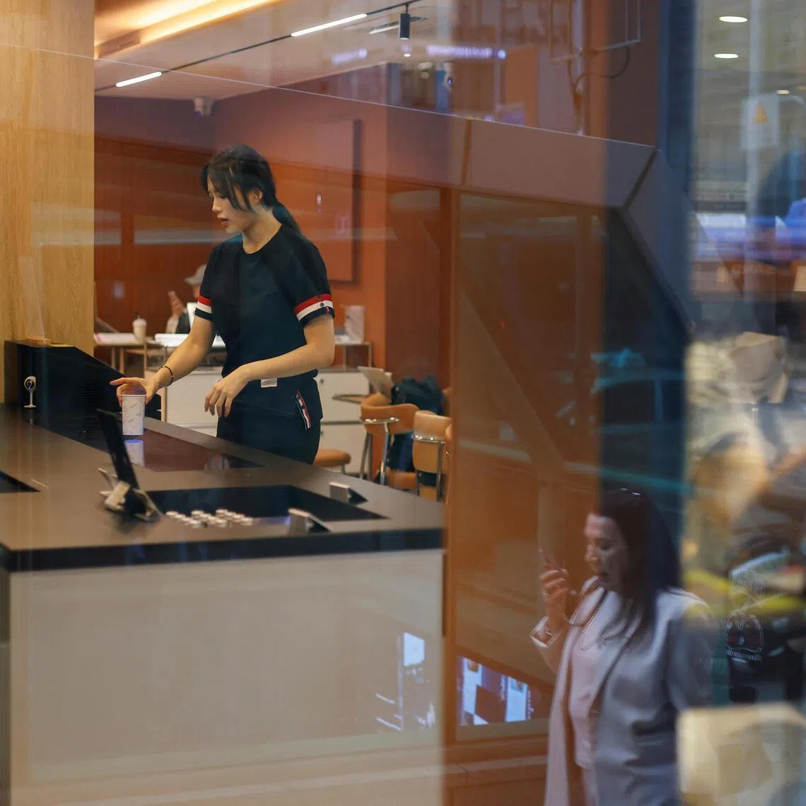 A customer gets coffee prepared by a robot arm at an unmanned cafe in Seoul, South Korea.