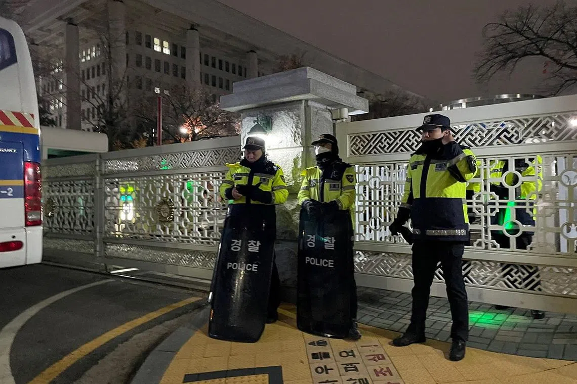 Police officers standing guard in front of the gate to the National Assembly martial law was declared, in Seoul, South Korea, on Dec 3.
