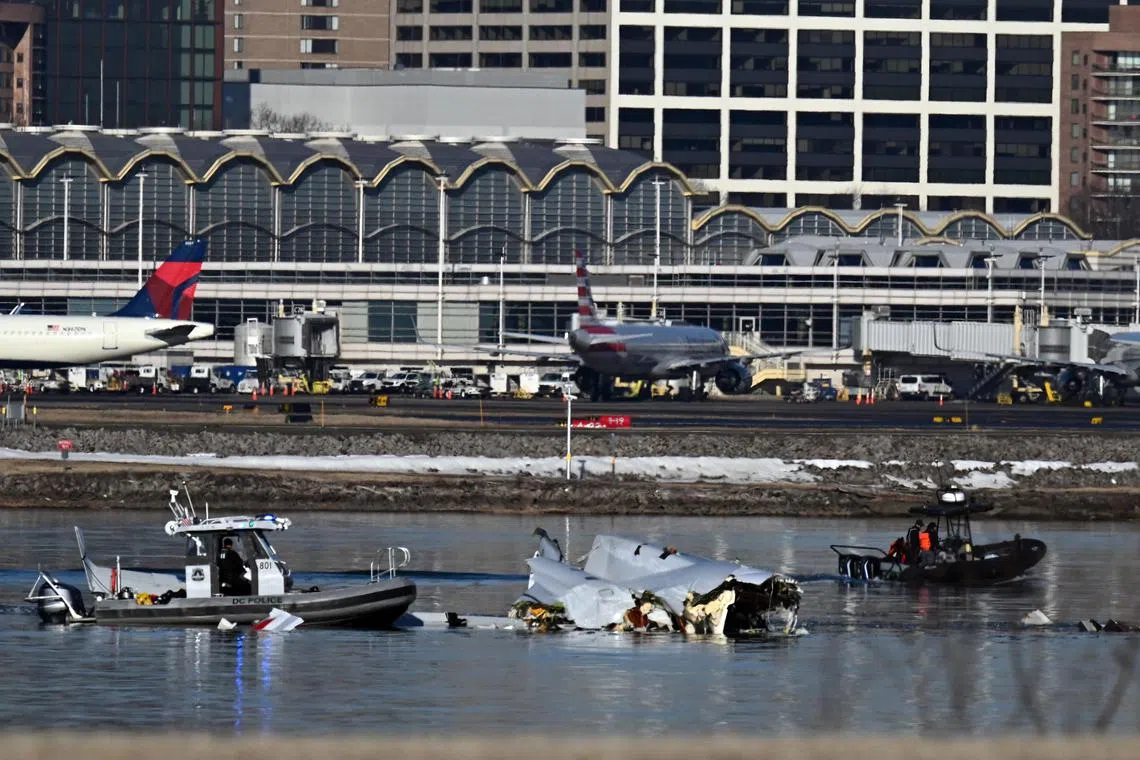 Emergency workers investigating crash wreckage in the Potomac River as dawn breaks over Ronald Reagan Washington National Airport, in Arlington, Virginia, on Jan 30.