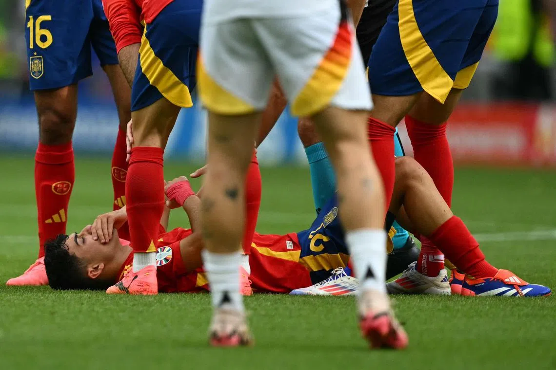 Spain's midfielder Pedri lying on the pitch after colliding with Germany's midfielder Toni Kroos (unseen), on July 5.