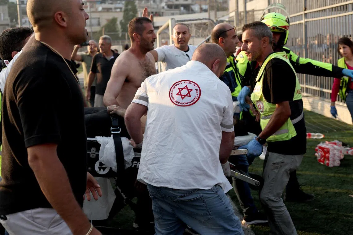Emergency service staff and locals tend to the injured, at the site of an attack in the Israeli-occupied Golan Heights. 