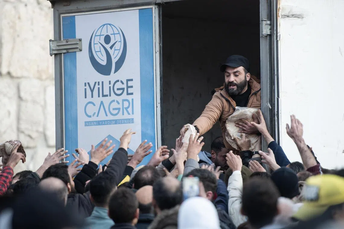 People queuing in Damascus to receive bread from a Turkish humanitarian organisation, amid a bread shortage in Syria, on Dec 9.