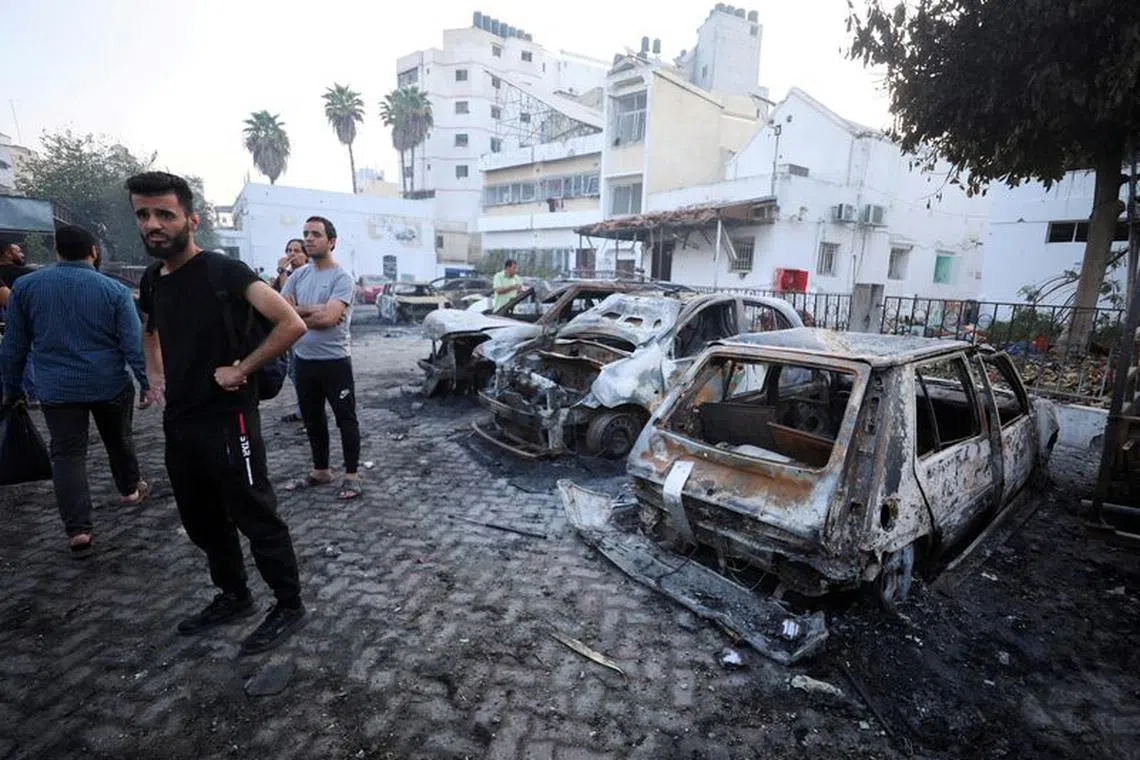 FILE PHOTO: People inspect the area of Al-Ahli hospital where hundreds of Palestinians were killed in a blast that Israeli and Palestinian officials blamed on each other, and where Palestinians who fled their homes were sheltering amid the ongoing conflict with Israel,  in Gaza City, October 18, 2023.  REUTERS/Mohammed Al-Masri/File Photo