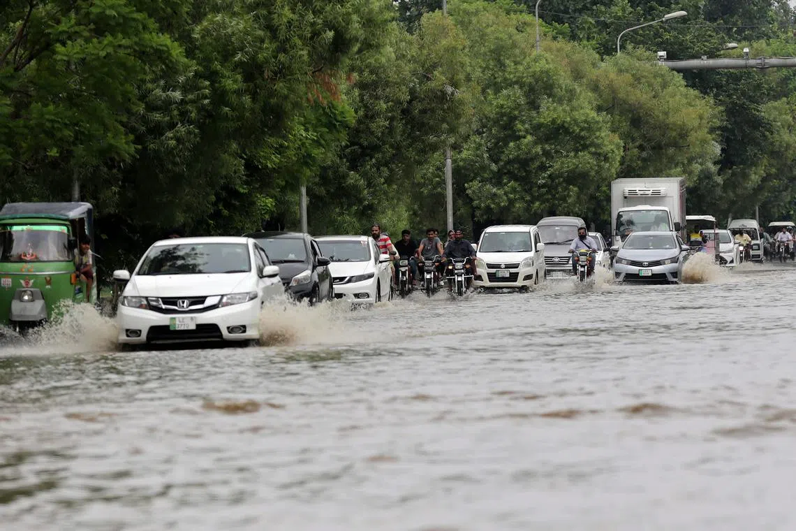 Vehicles driving through a flooded area following heavy rains in Lahore, Pakistan, on July 5.