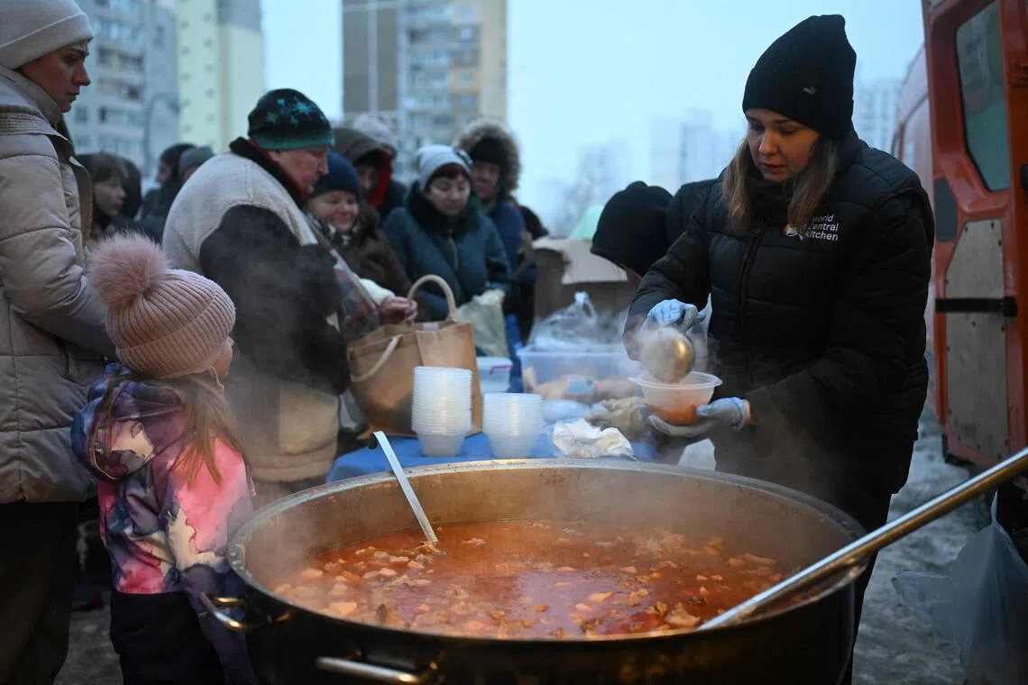 Volunteers of US-based food charity World Central Kitchen distributing a hot meal on Jan 22 to residents in Kyiv, which has been left without electricity and water due to Russian strikes on Ukraine's energy sector.