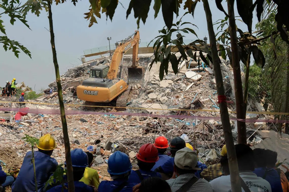 Heavy construction equipment is used to look for people trapped under the rubble at the collapsed Sky Villa Condominium development in Mandalay, on April 1.