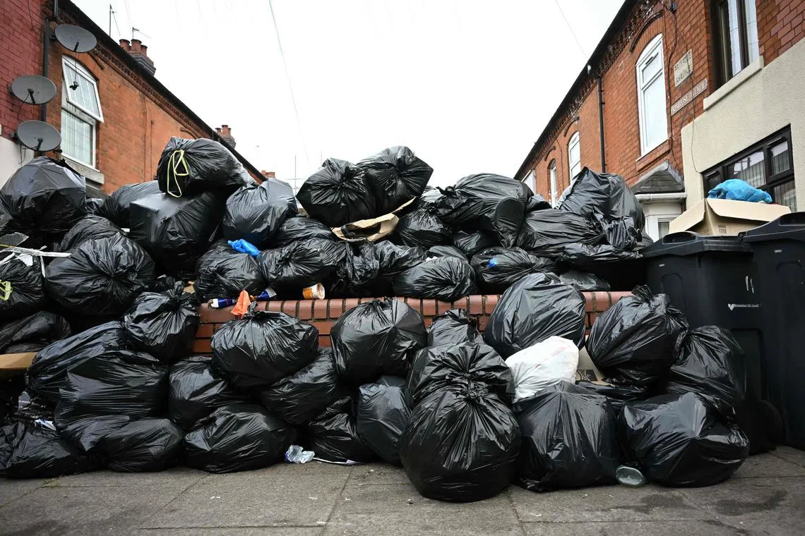 Uncollected bin bags pile up on Poplar Road in Birmingham, central England, on April 15, 2025. Residents are desperately trying to get rid of an estimated 17,000 tonnes of trash that has piled up since refuse workers ramped up a strike last month. Four weeks in, the city council has declared a "major incident," the prime minister has had to defend the government's response in parliament, and residents say their problems are worsening by the day. (Photo by Paul ELLIS / AFP)