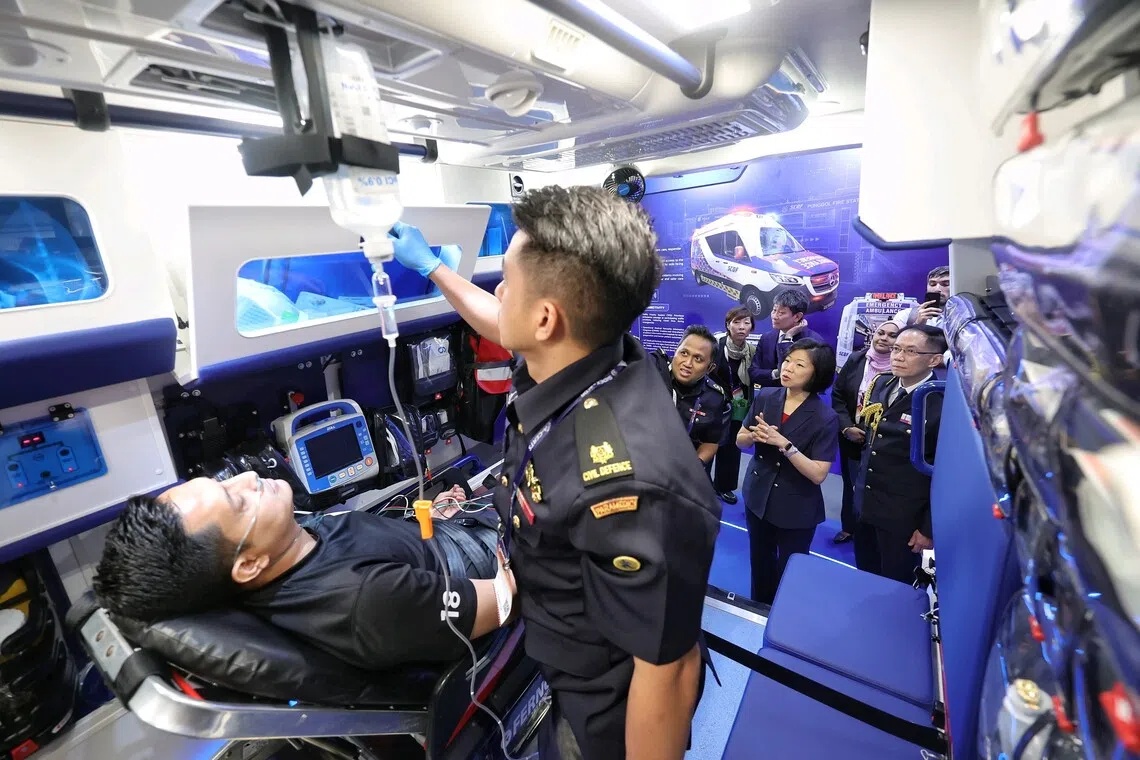 Second Minister for Home Affairs Sim Ann, accompanied by SCDF commissioner Eric Yap (right), watching a demonstration of the capabilities of the new generation ambulance.