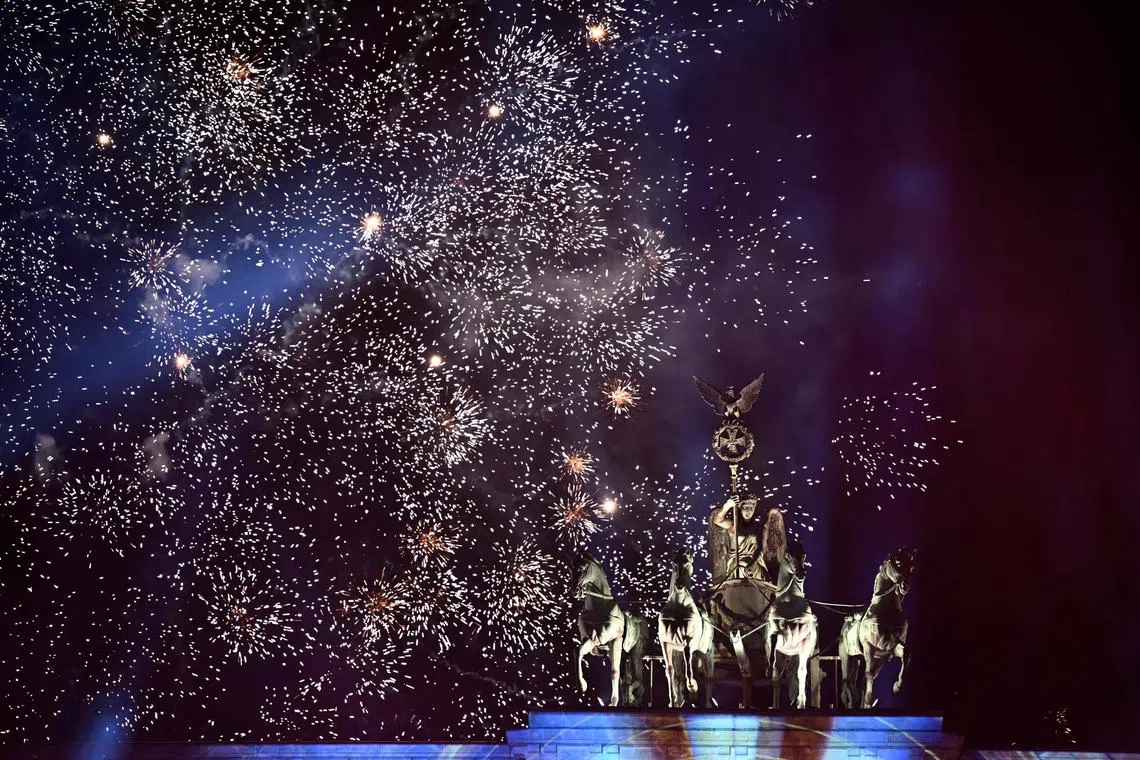 Fireworks explode over Berlin's landmark the Brandenburg Gate during a New Year's light and music show before midnight to welcome the year 2023, on Dec 31, 2022. The world's eight billion people have begun ushering in 2023 and bidding farewell to a turbulent 12 months marked by war in Europe, stinging price rises, Lionel Messi's World Cup glory and the deaths of Queen Elizabeth, Pele and former pope Benedict. 