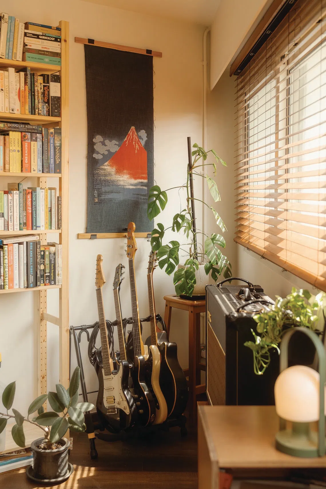 O escritório, localizado no canto mais pontiagudo do apartamento, está repleto de violões, livros e arte.