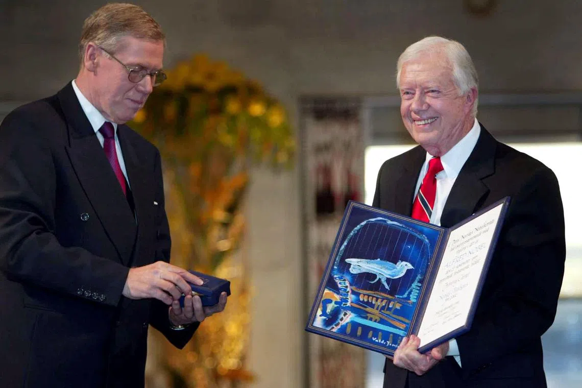 FILE PHOTO: Former U.S. President Jimmy Carter receives his Nobel Peace Prize December 10, 2002 from chairman of the Norwegian Nobel Committee Gunar Berge (L) for decades of work for peace democracy and human rights from the Middle East to Haiti. REUTERS/POOL/Bjoern Sigurdson OWE/WS/File Photo