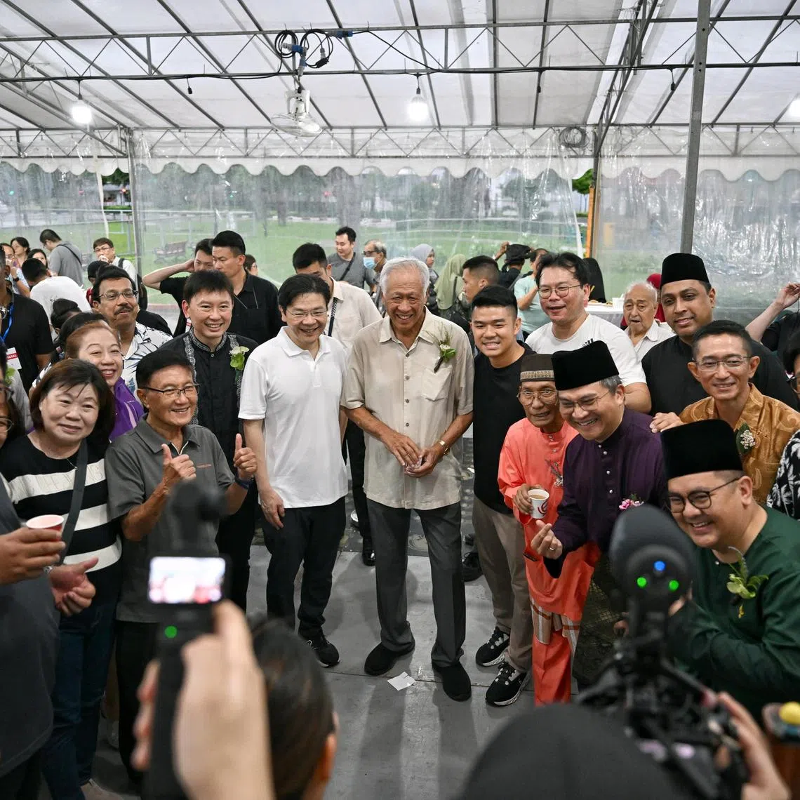 Prime Minister Lawrence Wong with Defence Minister Ng Eng Hen and Transport Minister Chee Hong Tat, taking a picture with attendees at Bishan-Toa Payoh and Marymount Hari Raya celebration at Plaza 128 on Apr 19, 2025.