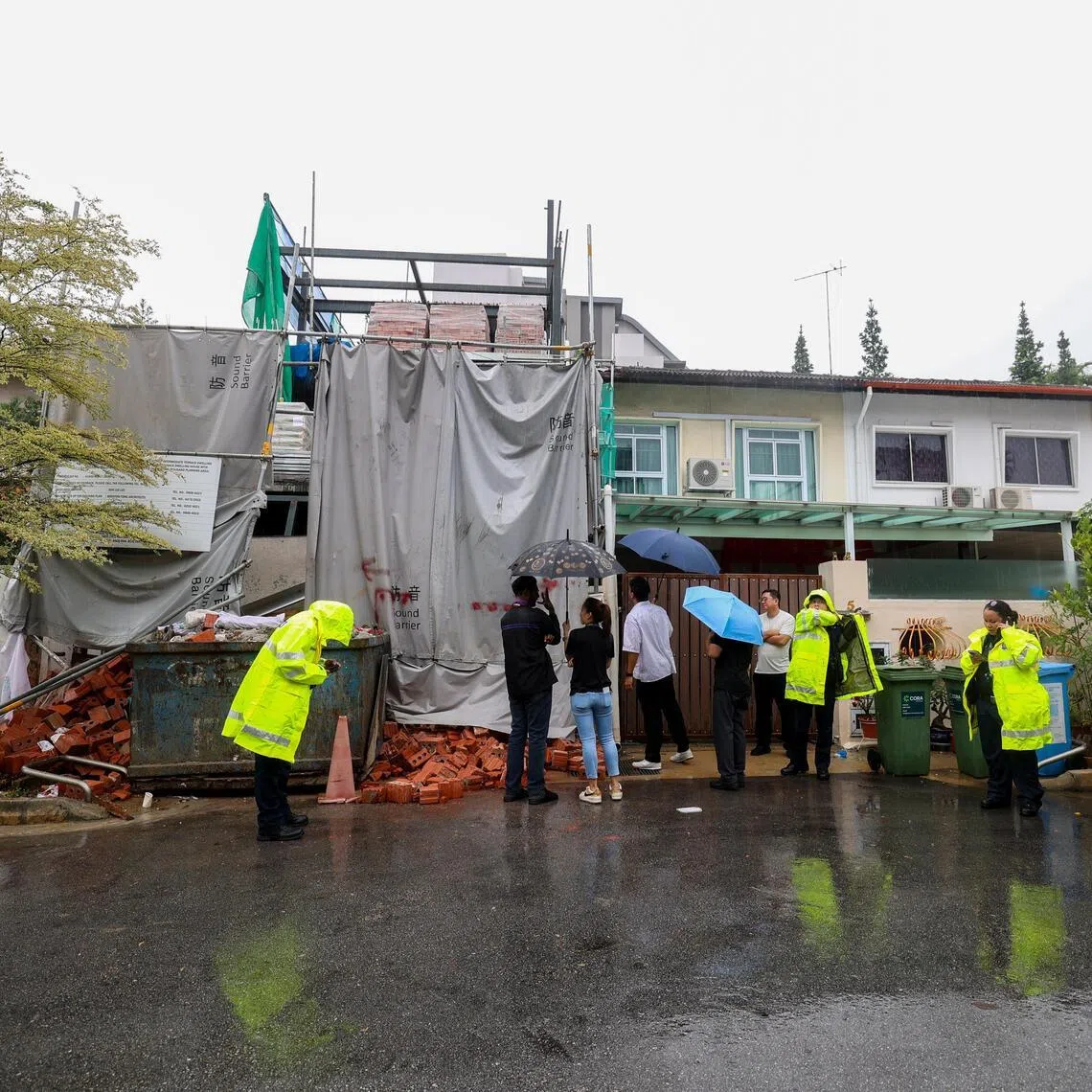Police officers and investigators at Jalan Usaha after bricks fell onto a worker at a construction site.