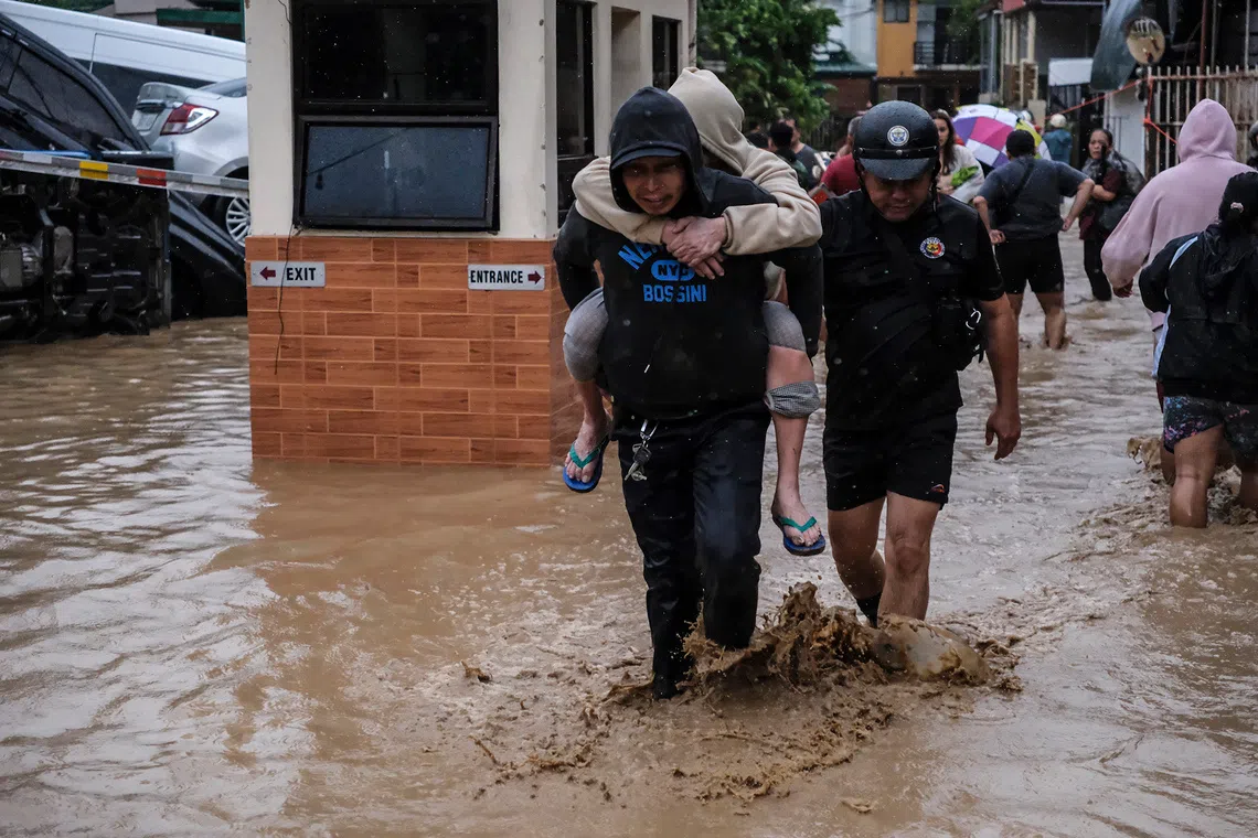 People walking in a flooded street caused by Typhoon Kalmaegi, in Cebu, Philippines, on Nov 4, 2025. 