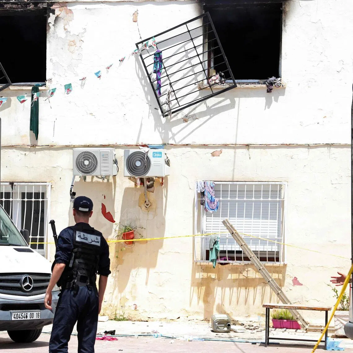 Police officers stand guard at the entrance of an orphanage following a fire in the Mohammadia suburb of Algiers on July 16, 2026.